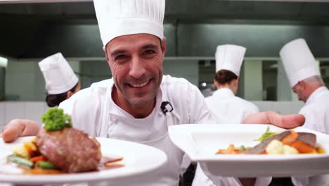 chef feliz mostrando dos platos a la cámara