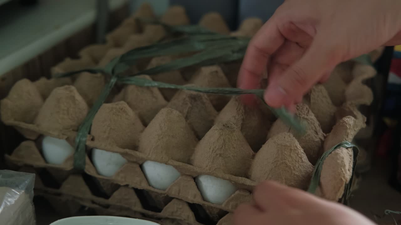 Hands Using Scissors In Cutting Plastic Straw Tied On Trays of Eggs In House. closeup shot