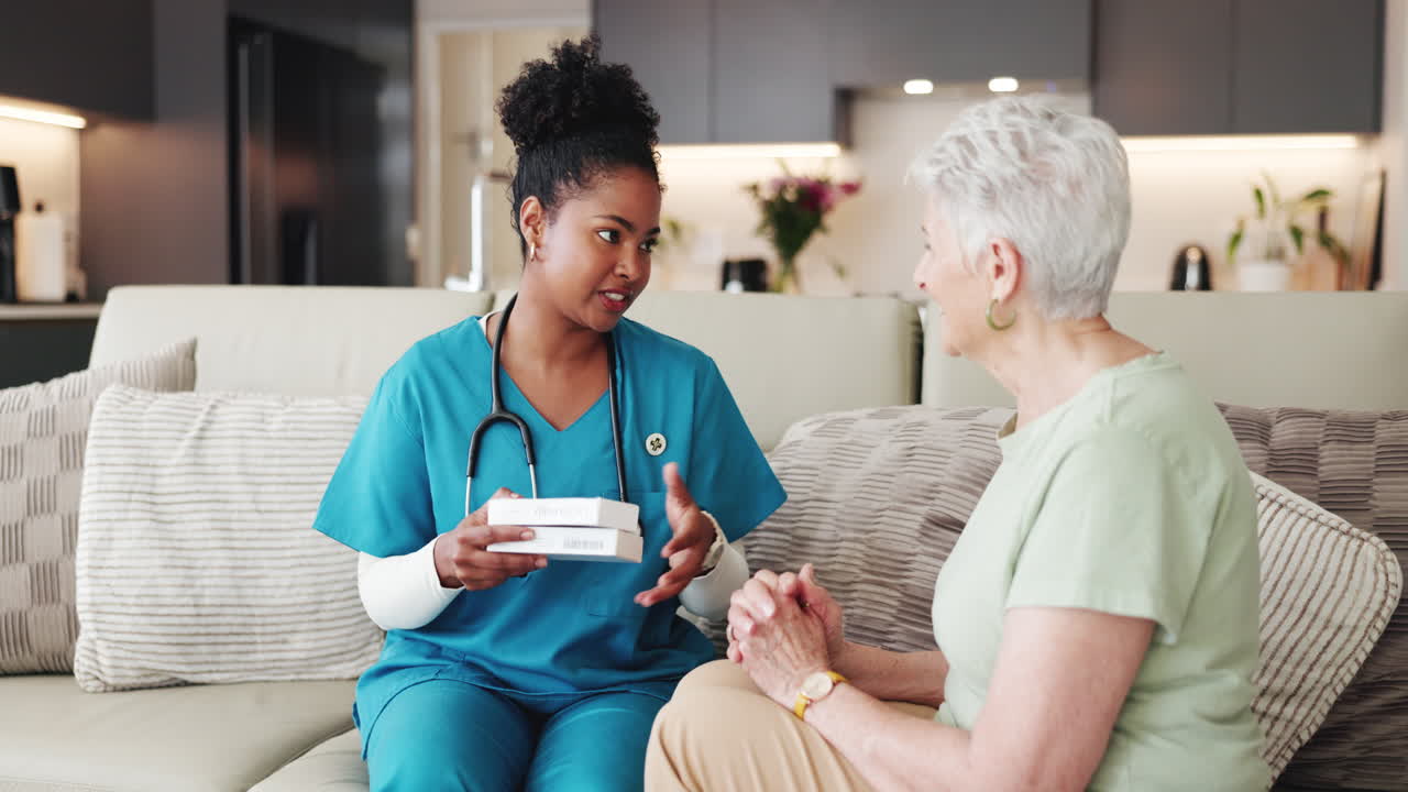 Nurse Explaining Medication to Elderly Woman During Home Visit