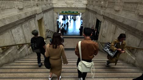 people walking down stairs towards train platforms