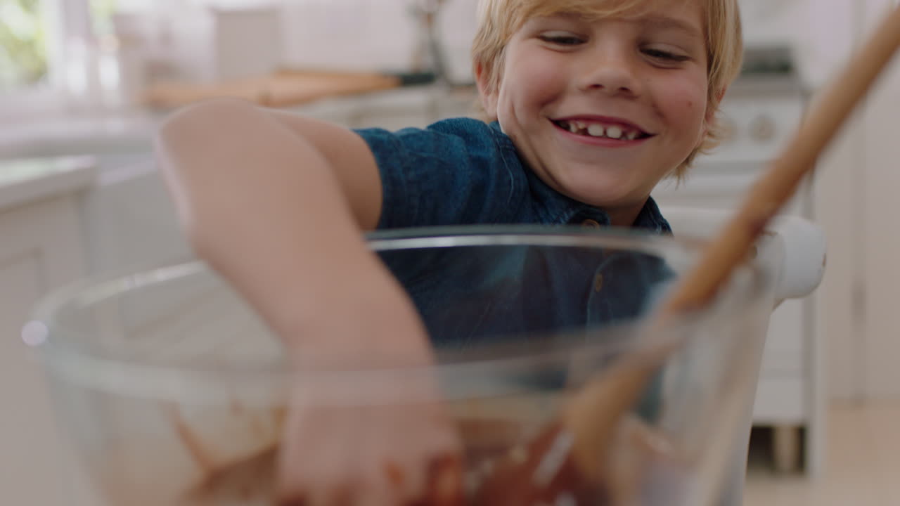 ragazzino cattivo che immerge la mano in una ciotola di salsa al cioccolato sorridente bambino furtivo che si diverte in cucina