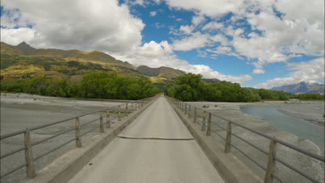 driving on glenorchy-paradise road bridge crossing rees river delta in new zealand