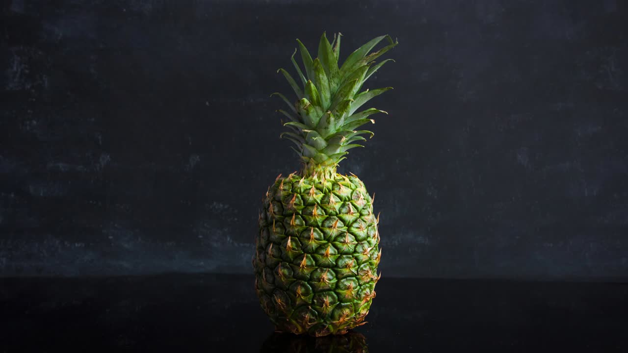 stop motion frutas tropicales maduras de piña sobre un fondo negro. imágenes de bucle de alimentos de lapso de tiempo