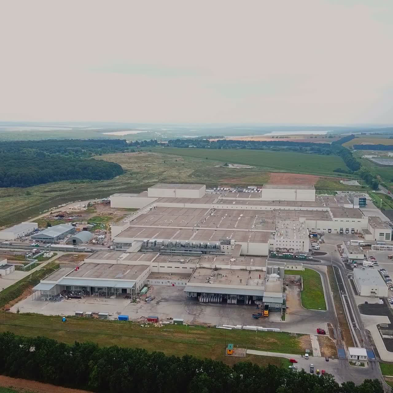 Aerial view of a factory or industrial area surrounded by green fields. Modern industrial factory