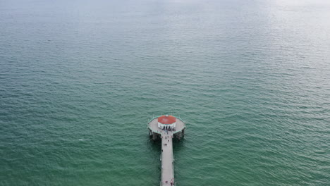muelle de madera de agua interminable con edificio al final, vista aérea