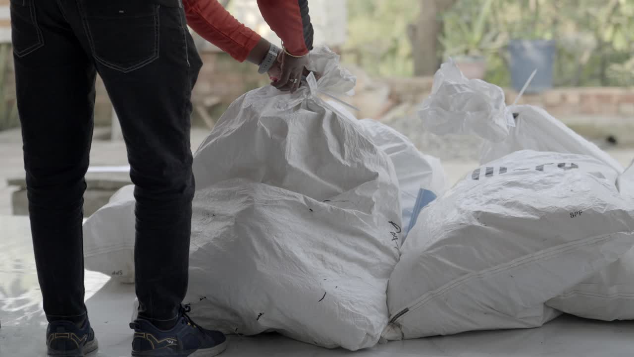 Addetto che taglia un pacco sigillato di merce presso una società di logistica e supply chain, Bihar