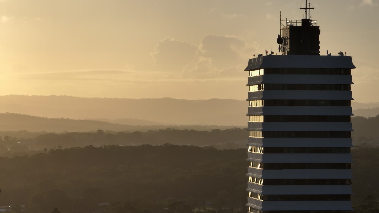 telephoto panning drone parallax edificio de gran altura con vistas a las montañas del interior al atardecer, drone 4k