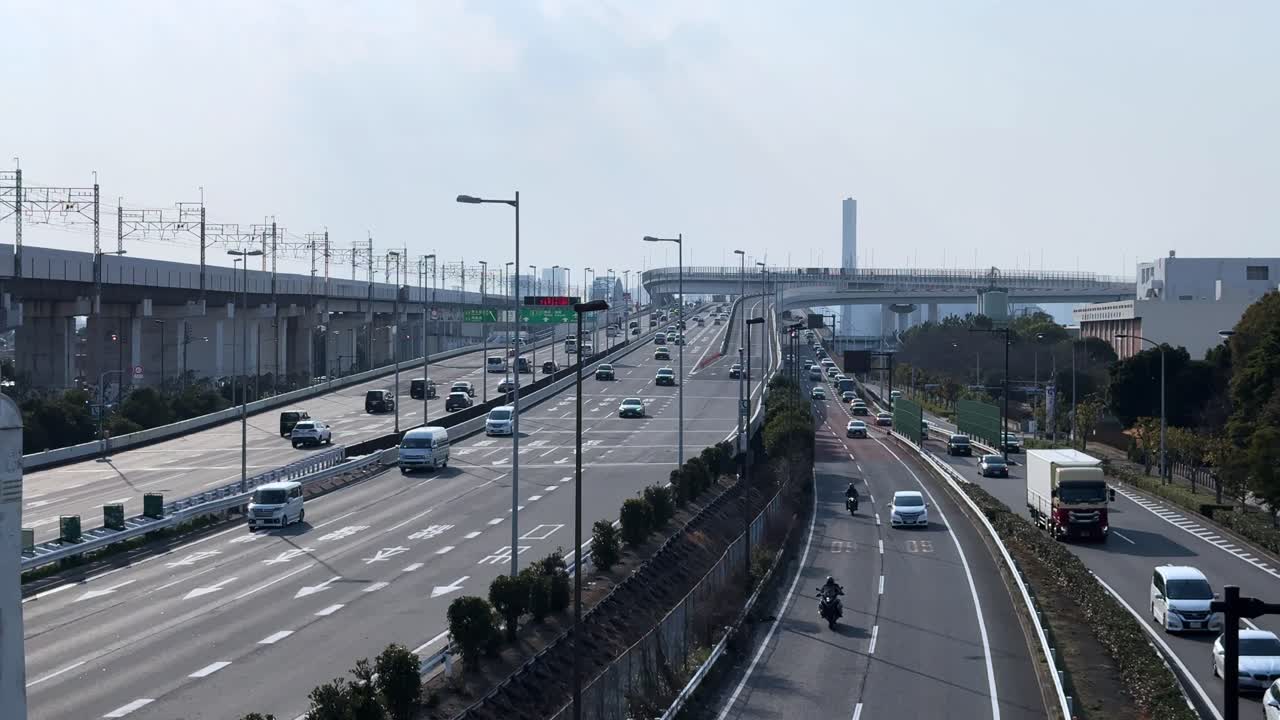 Wide-angle view of a highway in Tokyo with vehicles, including cars and motorcycles, on the road