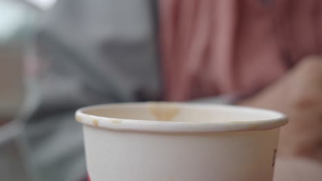 person holding a disposable coffee cup