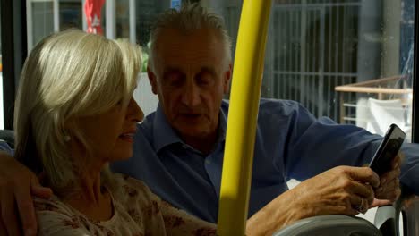 senior couple taking selfie on mobile phone while travelling in bus 4k