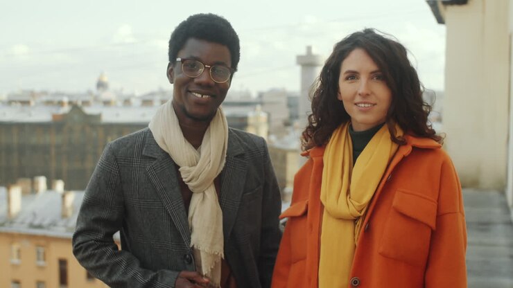 Portrait d'homme et femme multiethniques souriants sur une terrasse de toit