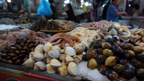 assortment of fresh seafood on ice at a market stall