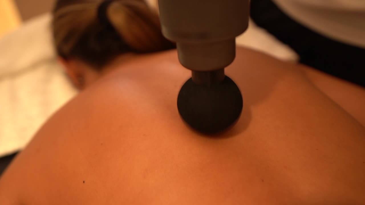 Ryggmassage med massagepistol