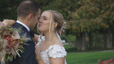 Bride-and-groom-kiss-and-rub-noses-while-smiling-happily