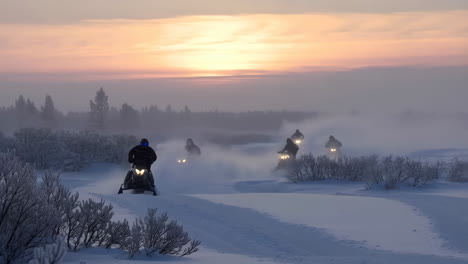 snowmobiling adventure at sunset in a snowy landscape