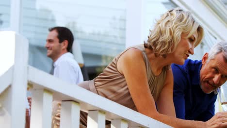 friends interacting while having champange in balcony