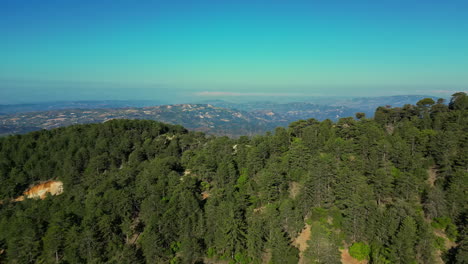 a drone flies over the mountain forests showing the wide horizon