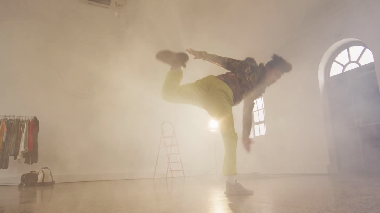 retrato de un bailarín masculino biracial bailando en un estudio de baile, cámara lenta