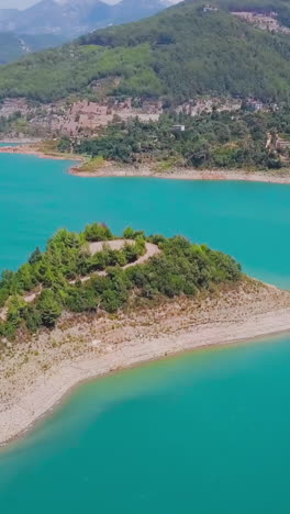 vista aérea de un lago turquesa con las montañas y colinas circundantes