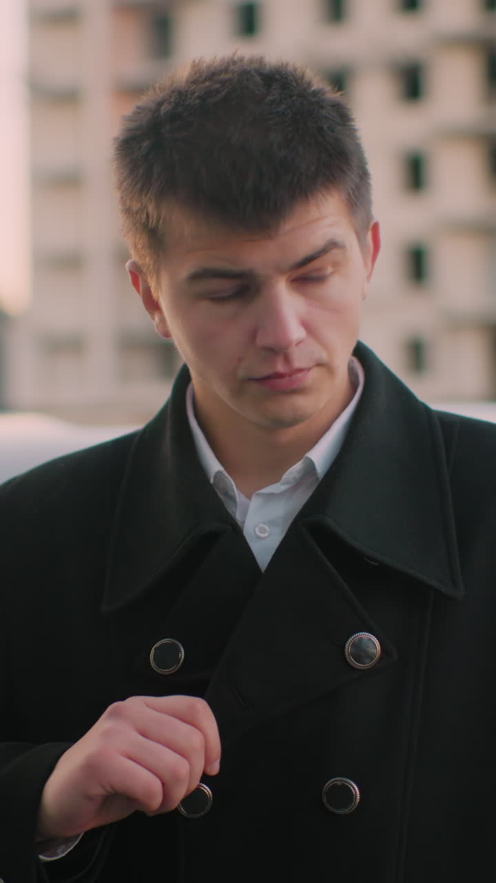 고급 자동차 근처에 서 있는 사업가, 옷 목걸이를 조정하고, 생각에 빠져, 사무실 건물과 주차된 자동차를 배경으로, 결정에 대해 반영하고