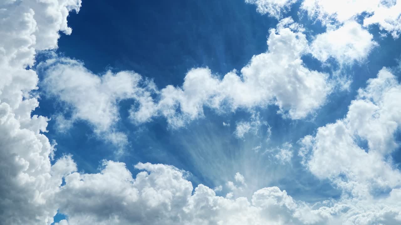 Eine ruhige Video-Szene mit hellen, fluffigen Wolken vor einem leuchtend blauen Himmel, aufgenommen aus einem niedrigen Winkel