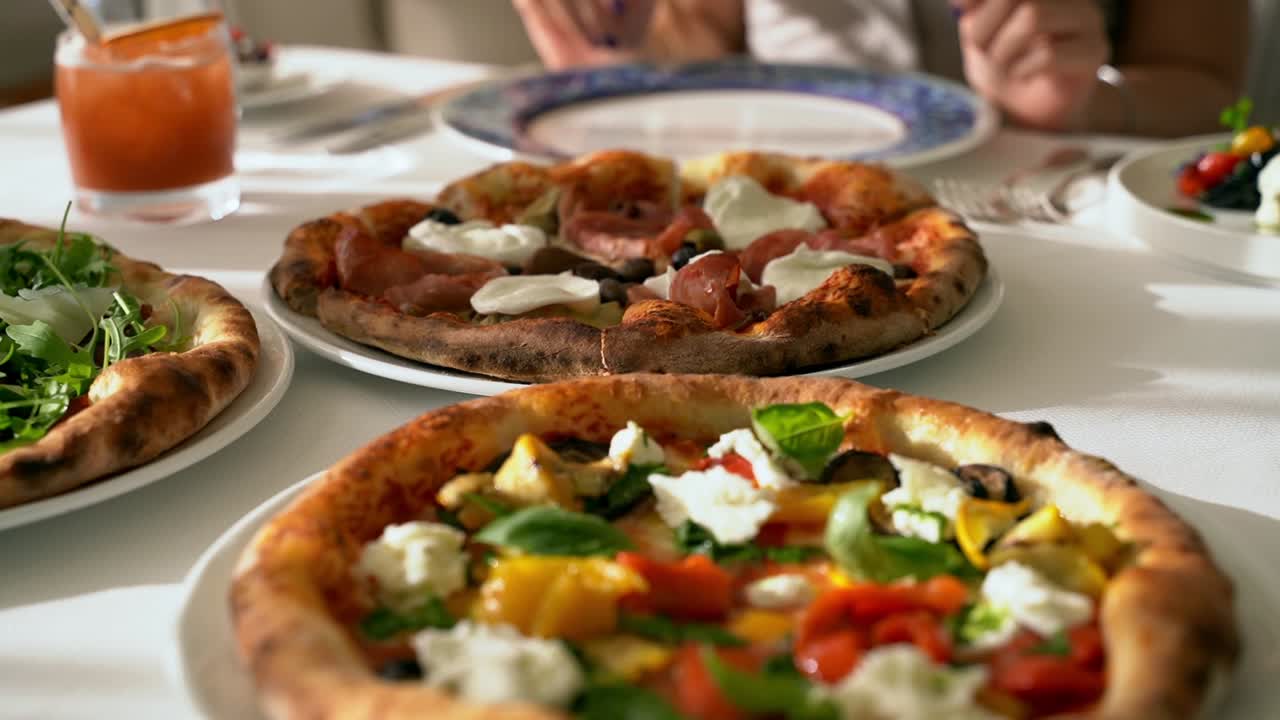 Female hand reaching for a slice of deliciously made fresh pizza
