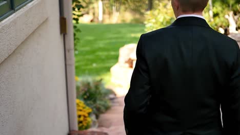 Slow-motion-shot-from-behind-an-androgynous-queer-person-as-they-walk-down-stone-steps-of-the-wedding-venue