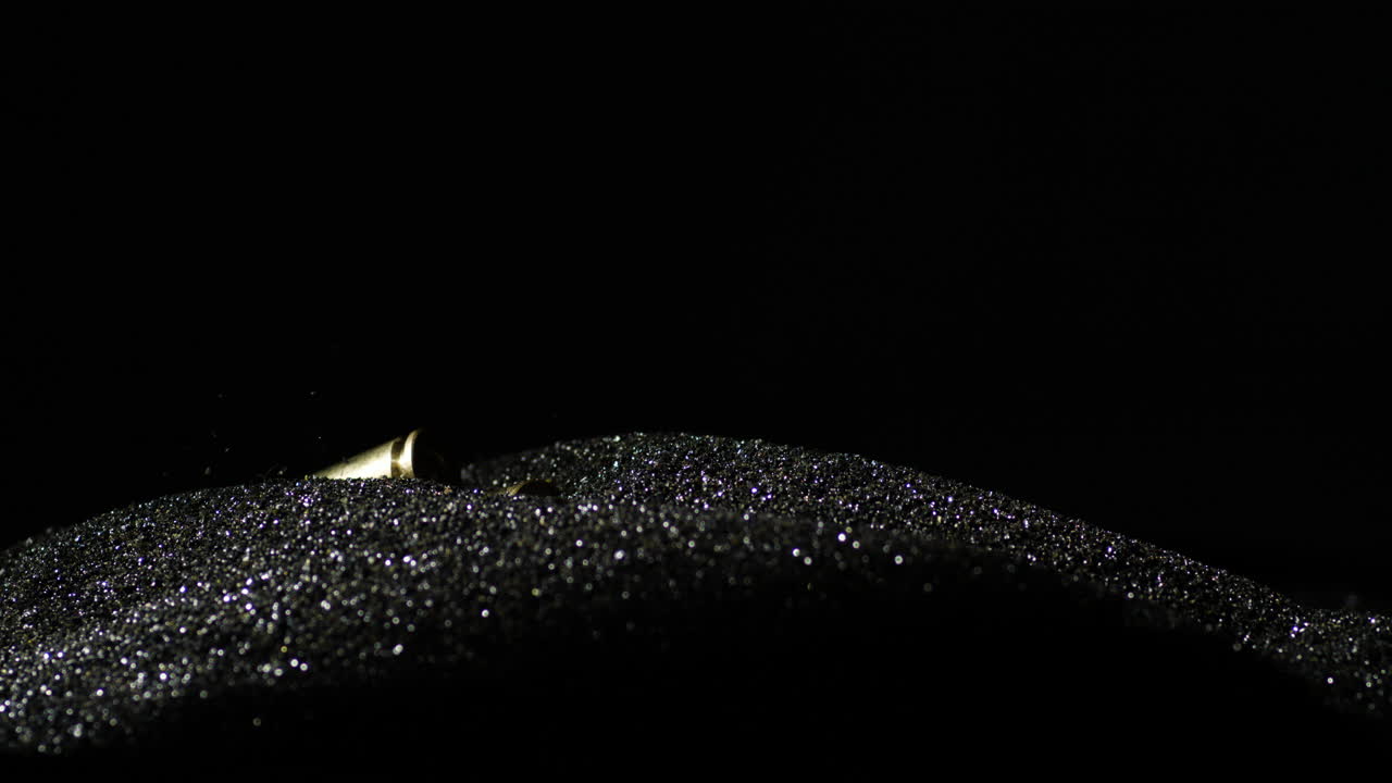 6mm 소총 카트리지가 검은 가루에 떨어졌습니다.