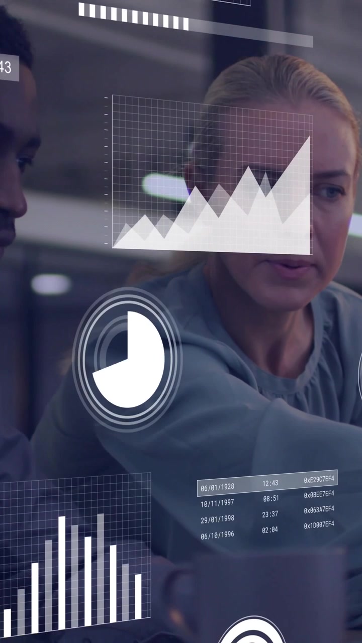 Vertical video: Two colleagues leaning and pointing at display animating charts for business data