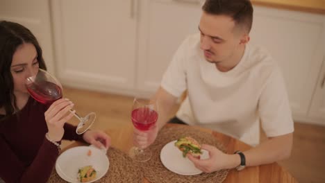 una pareja enamorada haciendo un sándwich en la cocina de la sala de estar