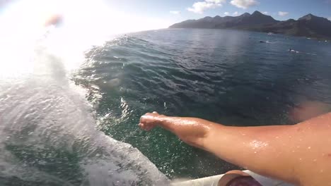 man surfing pov first view in moora haapiti surf spot. sunny day