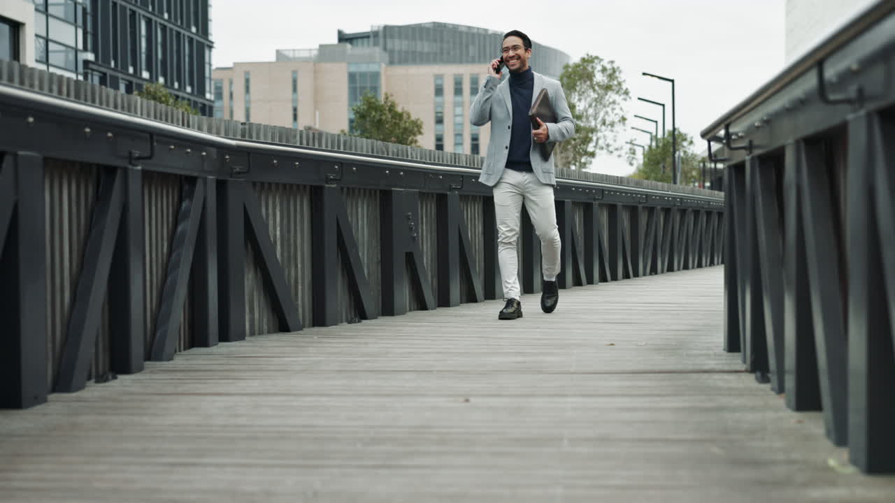 un hombre camina por un puente y habla por teléfono en una ciudad