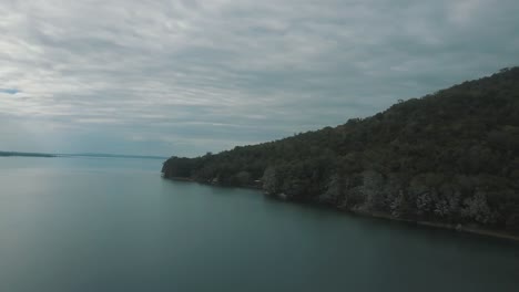 drone aerial view of and beautiful clear lake peten itza, el remate, guatemala in a cloudy day