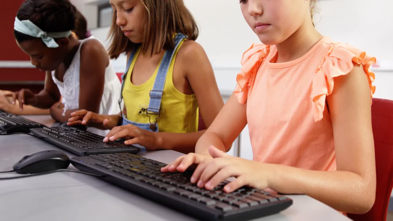 Schoolgirls using computer in classroom