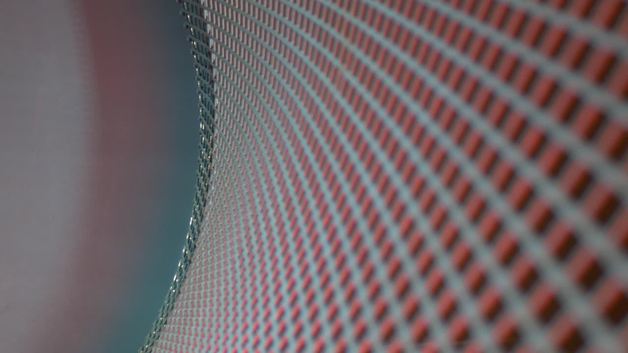 отходя от изогнутой металлической решетки, синей с одной стороны, красной с другой