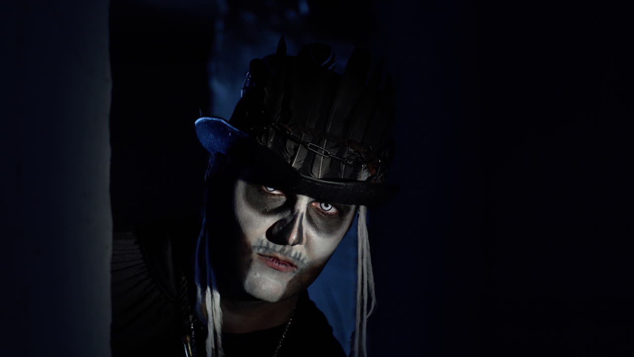 un hombre espeluznante con maquillaje de esqueleto de halloween aparece lentamente desde una esquina oscura, tratando de asustar