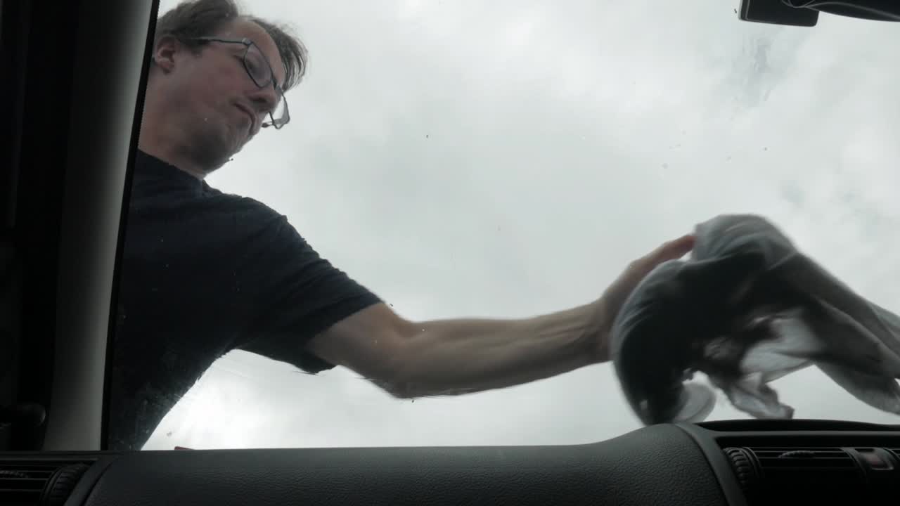 그의 차량 앞 유리창을 세척하는 국내 남자