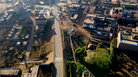 Sunrise--Kenya-landscape-with-a-village,-Kilimanjaro-and-Amboseli-national-park---tracking,-drone-aerial-view