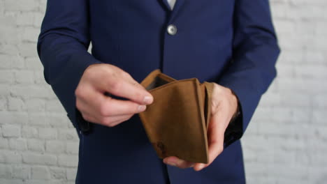 a business man looking for cash in an empty wallet