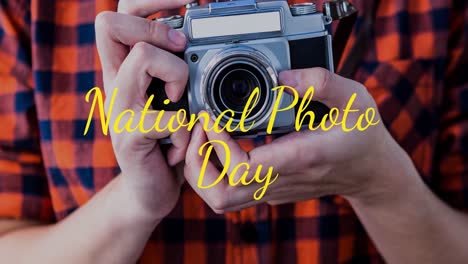 animation of caucasian man holding camera over national photo day text