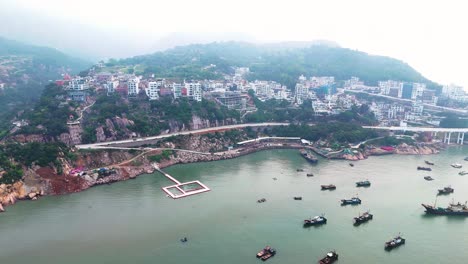 Aerial-orbiting-shot-of-the-beautiful-Xiapu-cityscape-with-boats-docked,-Fujian-Province,-China