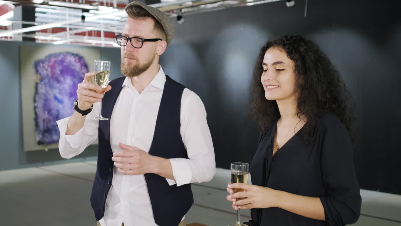una pareja disfrutando de champán en una galería de arte.