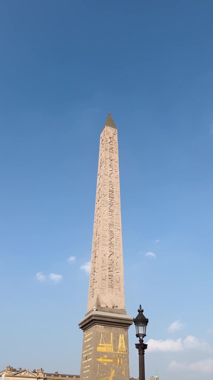 L'Obélisque de Louxor s'élève au-dessus de la Place de la Concorde sous un ciel bleu clair de Paris, plan vertical.