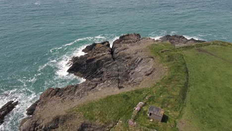 drone shot showing waves crashing against rocks in ireland