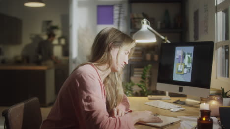 female designer drawing at cozy workplace at home