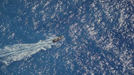 barco solitario que viaja sobre el océano azul durante el sol del mediodía, cámara lenta