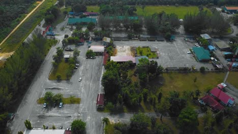 Cinematic-Drone-Footage-of-Palm-Oil-Mill-Effluent-residential-consists-of-buildings,-homes,-main-road-and-infrastructure-surrounded-by-palm-oil-trees-deforestation-located-in-Indonesia-in-full-HD