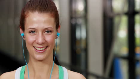 mujer en forma poniendo auriculares para escuchar música