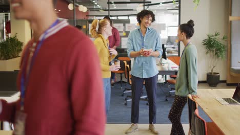 Happy-diverse-business-people-discussing-work-during-meeting-at-office