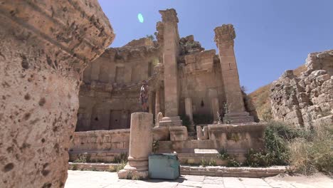 Abenteurer,-Der-In-Einer-Alten-Säule-Steht,-Sonneneruption,-Klarer-Himmel,-Jordanien,-Reisender-Schuss